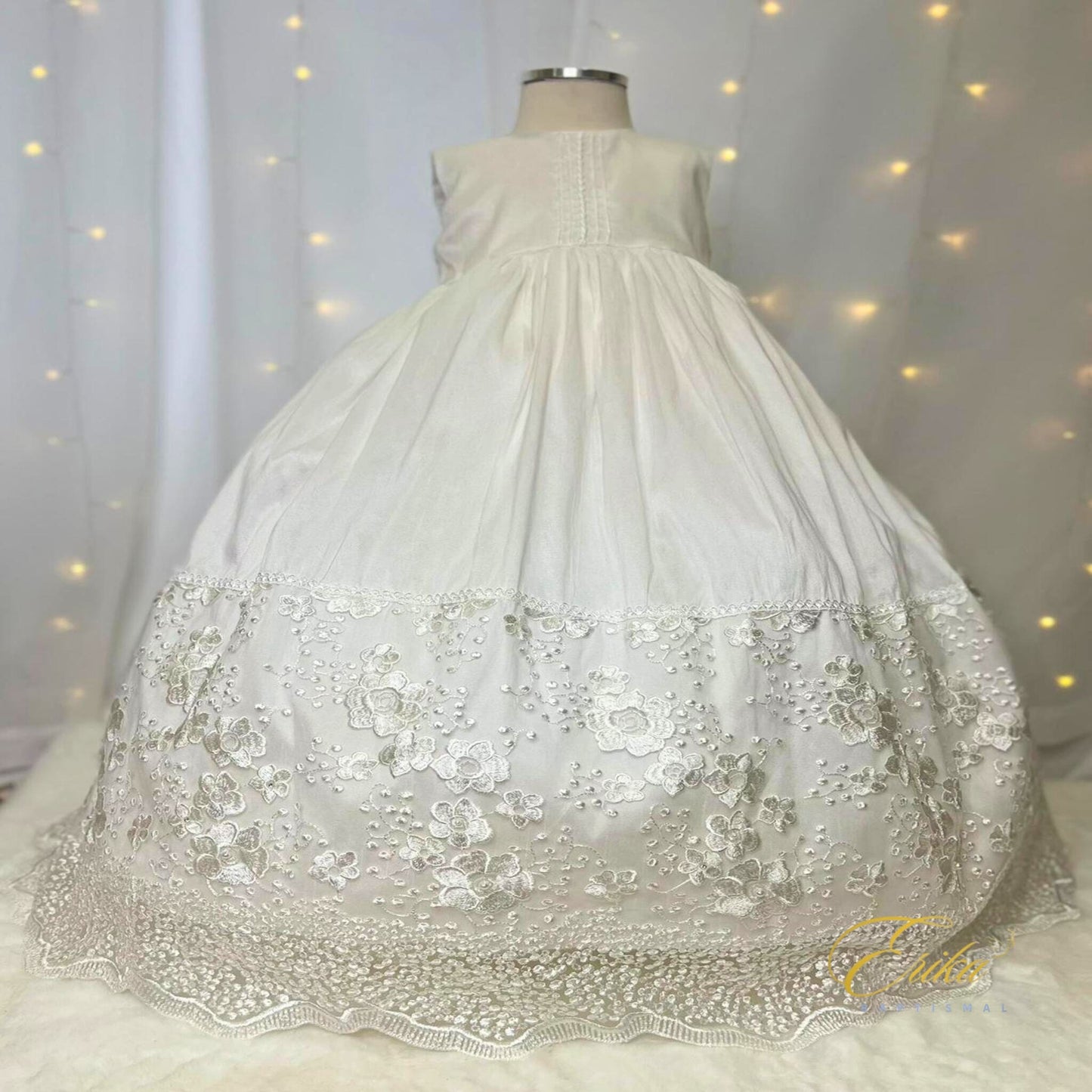 sophisticated white baby christening dress with silver embroidery and decorative floral waist