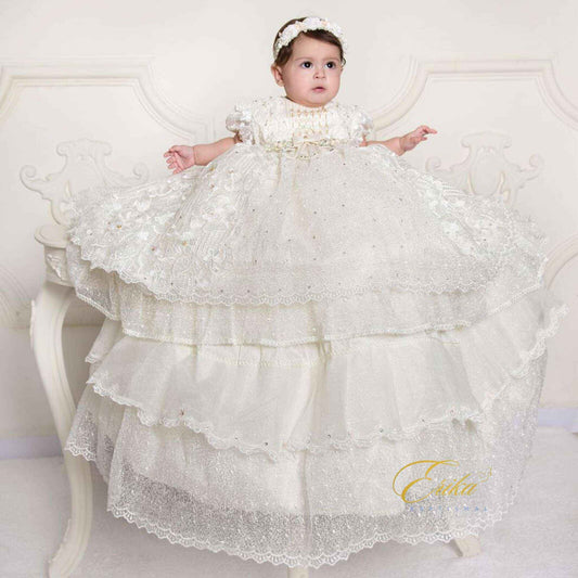 elegant white baby baptism dress with lace ruffles and delicate floral embroidery in lightweight fabric