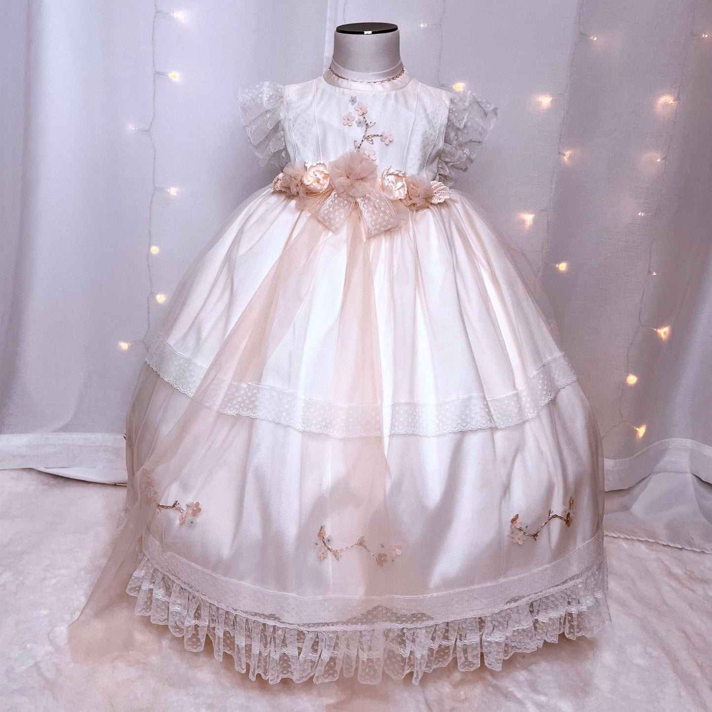 contemporary long white baby baptism dress with minimal floral embroidery and flowing tulle bottom