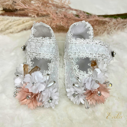 White lace christening shoes with pink flowers, crystal rhinestones, and brown ribbon accents
