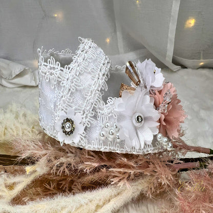 White lace christening shoes with pink flowers, crystal rhinestones, and brown ribbon accents.