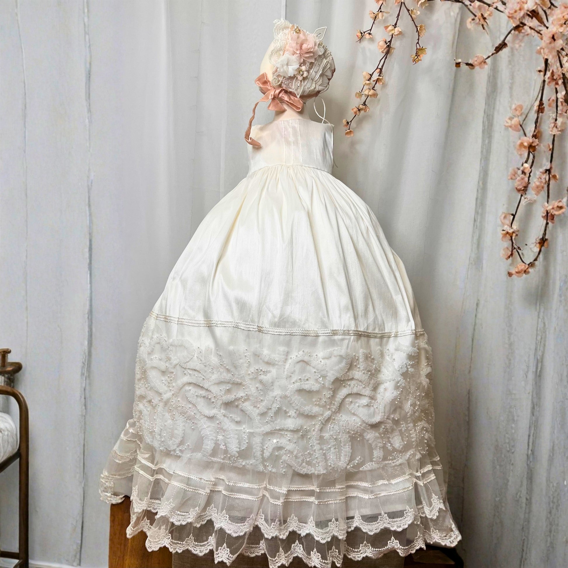 elegant baby baptism dress with layered ruffles and floral embroidery in soft fabric