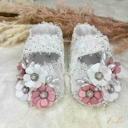 Ornate white lace christening flats with multi-colored flowers, silver beads, and brown ribbon detail