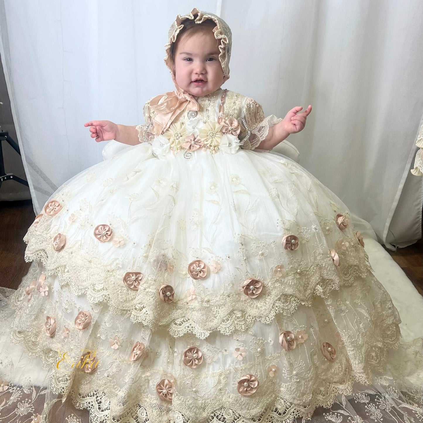 long baby christening gown with lace fabric and embedded floral accents in a soft flowing design