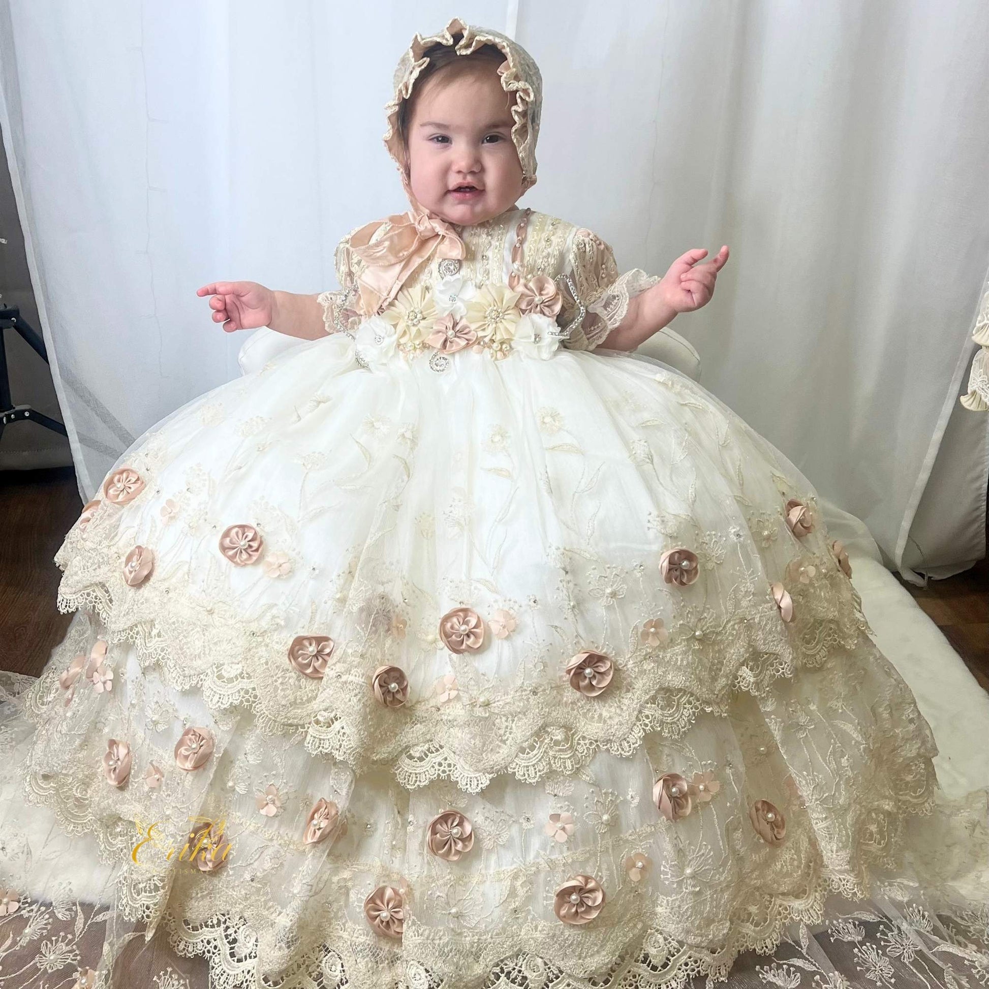 long baby christening gown with lace fabric and embedded floral accents in a soft flowing design