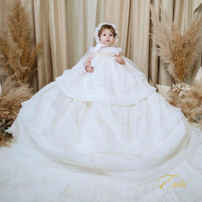 long modern white baby christening dress with subtle floral embroidery and light tulle at the bottom