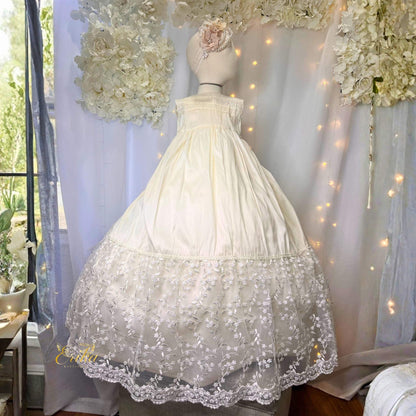 traditional long baby christening gown with lace ruffles and floral waistband in soft flowing fabric