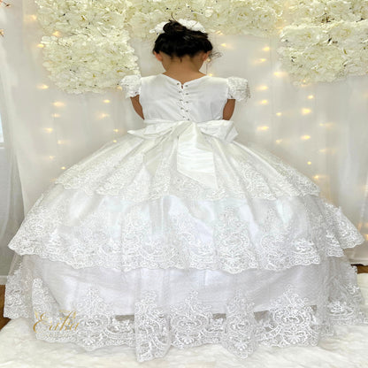 Close-up of the delicate lace bodice and floral belt on a white First Communion gown