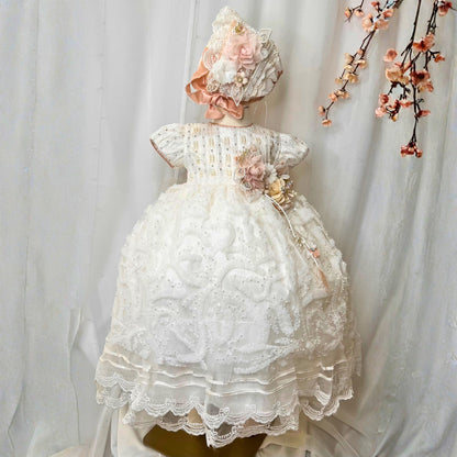 white baby christening dress with soft ruffles and floral embroidered details in lightweight fabric