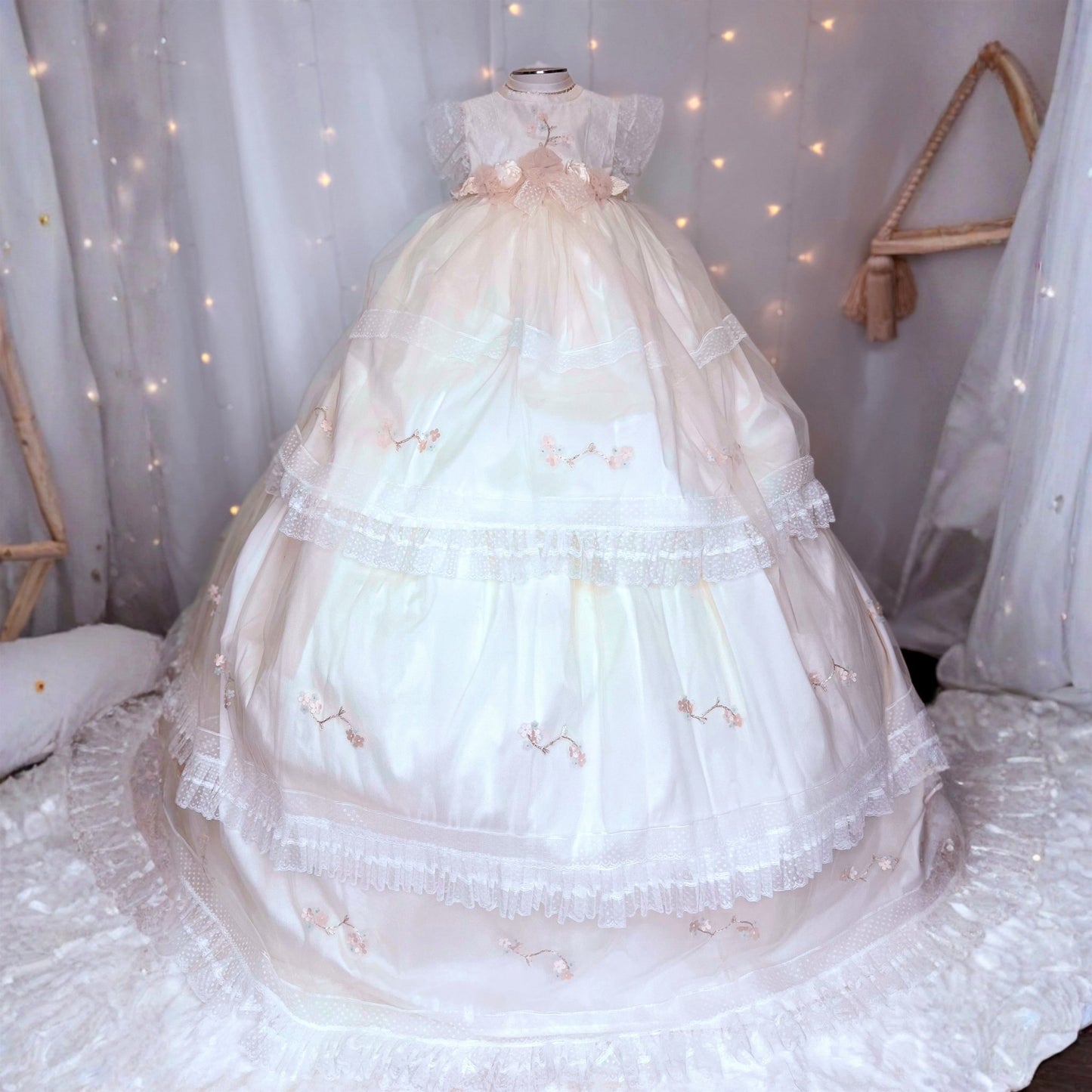 long white baby christening dress with small floral embroidery and soft tulle detail at the hem