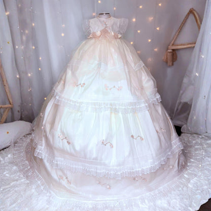 long white baby christening dress with small floral embroidery and soft tulle detail at the hem